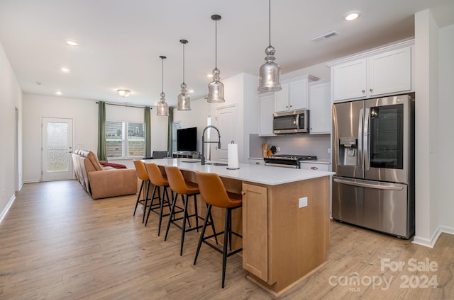 kitchen with visible vents, open floor plan, light countertops, stainless steel appliances, and backsplash