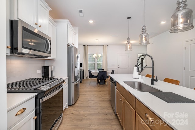 kitchen featuring stainless steel appliances, a sink, visible vents, light countertops, and decorative backsplash