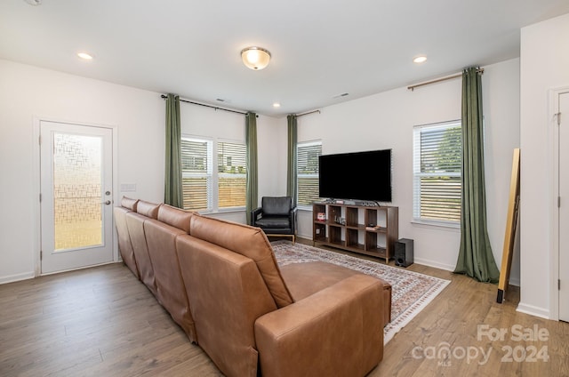 living area featuring recessed lighting, baseboards, and light wood finished floors