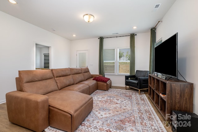 living room with baseboards, wood finished floors, visible vents, and recessed lighting