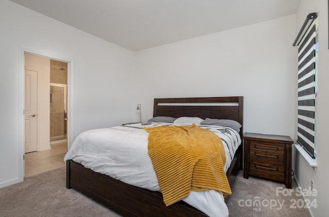 carpeted bedroom with baseboards and ensuite bathroom