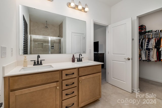 bathroom featuring a stall shower, tile patterned floors, a sink, and double vanity