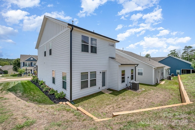 back of house with a yard, board and batten siding, and central air condition unit