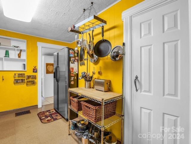 kitchen with visible vents, a textured ceiling, refrigerator with ice dispenser, and a toaster