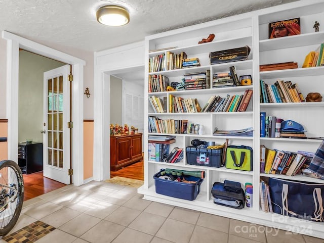 sitting room featuring a textured ceiling and tile patterned floors