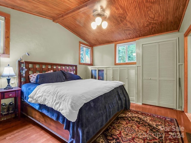 bedroom with lofted ceiling with beams, wooden ceiling, a ceiling fan, and wood finished floors