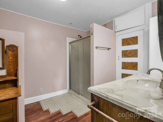 full bathroom with a stall shower, tile patterned flooring, vanity, and baseboards