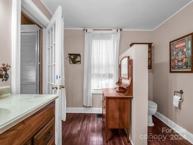 bathroom featuring vanity, wood finished floors, toilet, and baseboards