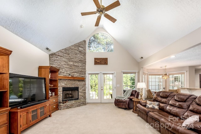 living room featuring a fireplace, light carpet, a textured ceiling, and ceiling fan