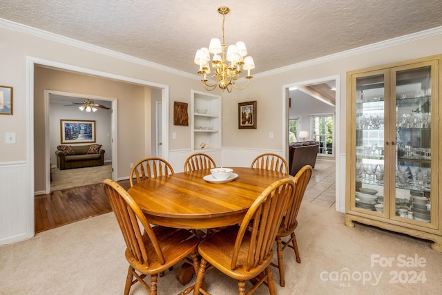 dining room with light wood-type flooring, ceiling fan with notable chandelier, ornamental molding, and a textured ceiling