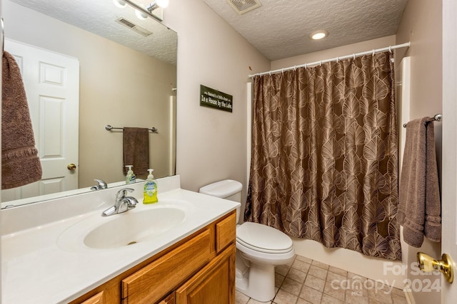 full bathroom with tile patterned flooring, toilet, vanity, shower / bath combo with shower curtain, and a textured ceiling