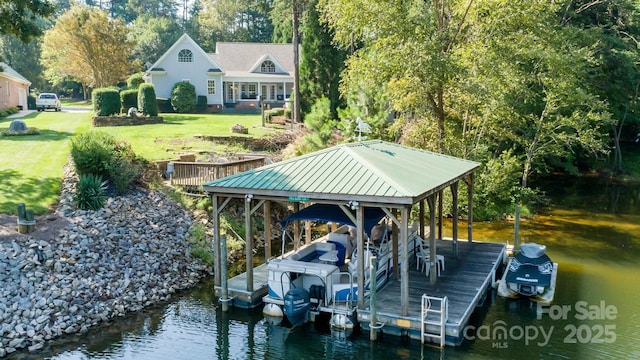 dock area featuring a water view, boat lift, and a yard