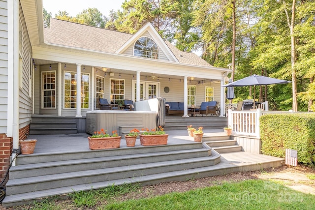 property entrance featuring a deck, an outdoor hangout area, and a shingled roof