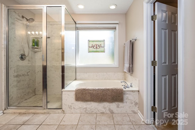 bathroom with a stall shower, a bath, and tile patterned flooring