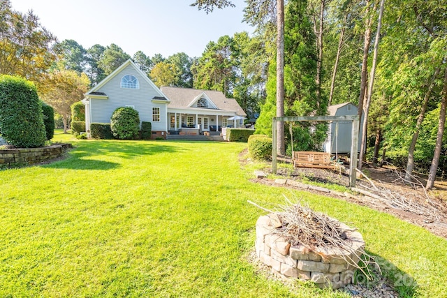 rear view of property with an outbuilding, an outdoor fire pit, crawl space, a porch, and a shed