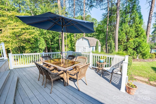 wooden deck featuring outdoor dining space, an outbuilding, and a storage shed