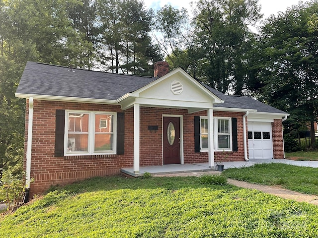 view of front of house with a front yard, covered porch, and a garage