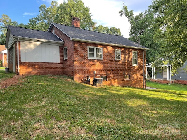 rear view of house with a gazebo, central AC unit, and a lawn