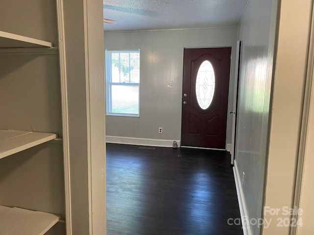 foyer entrance with dark wood-type flooring and a textured ceiling