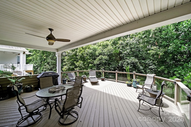 deck with outdoor dining area and a ceiling fan