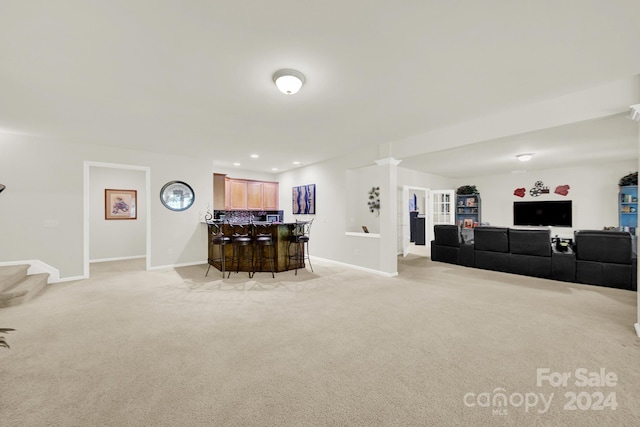 living area featuring baseboards, stairway, and light colored carpet