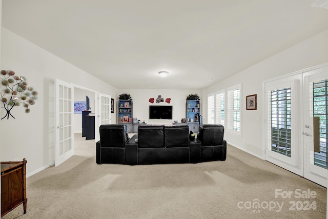 carpeted living room with baseboards and french doors