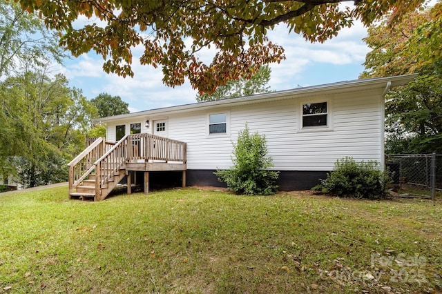 back of property with a lawn and a deck