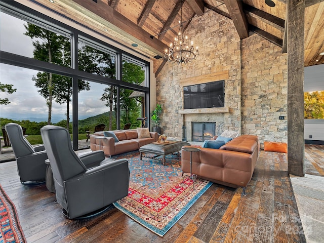 living room with dark hardwood / wood-style flooring, a notable chandelier, a stone fireplace, and high vaulted ceiling