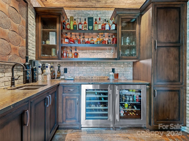 bar with sink, backsplash, dark brown cabinets, and beverage cooler