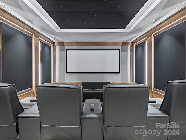 home theater room featuring hardwood / wood-style flooring and a tray ceiling