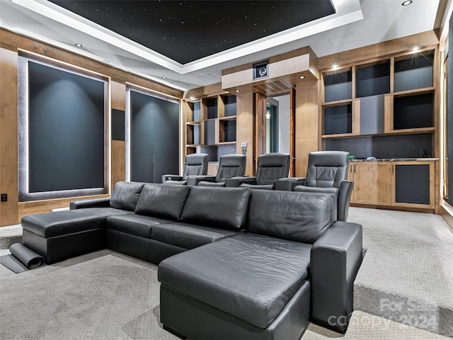 carpeted home theater with a tray ceiling and built in features