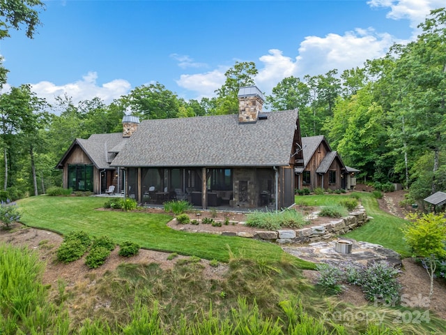 back of house with a lawn and a sunroom