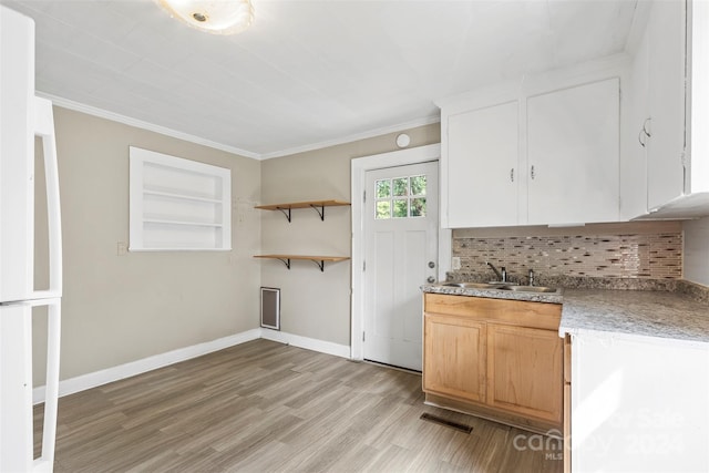 kitchen featuring crown molding, light hardwood / wood-style flooring, backsplash, built in features, and sink