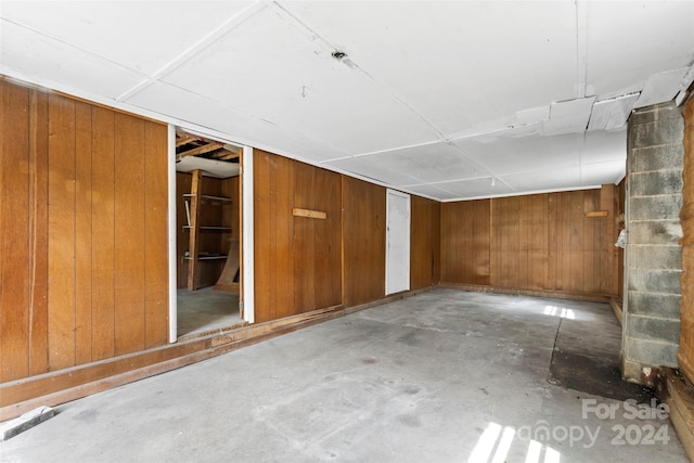 basement featuring wood walls