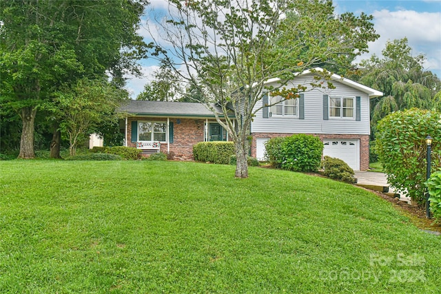 split level home with a garage and a front lawn