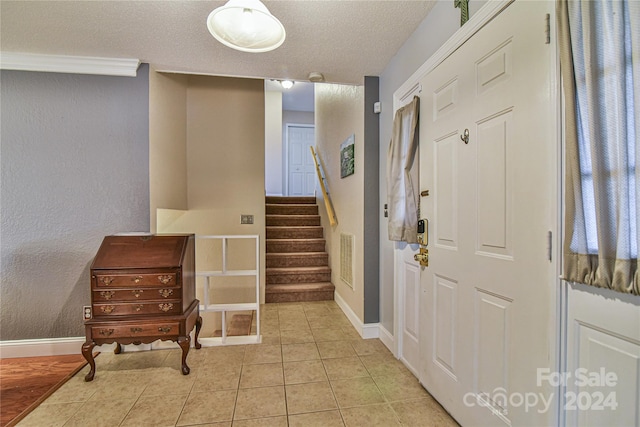 foyer featuring light tile patterned floors and a textured ceiling