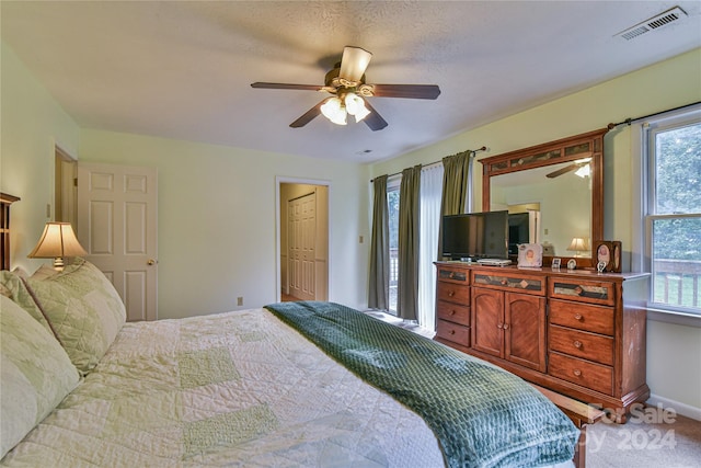 bedroom with ceiling fan, carpet flooring, and multiple windows