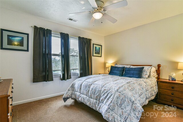 bedroom featuring a textured ceiling, carpet floors, and ceiling fan