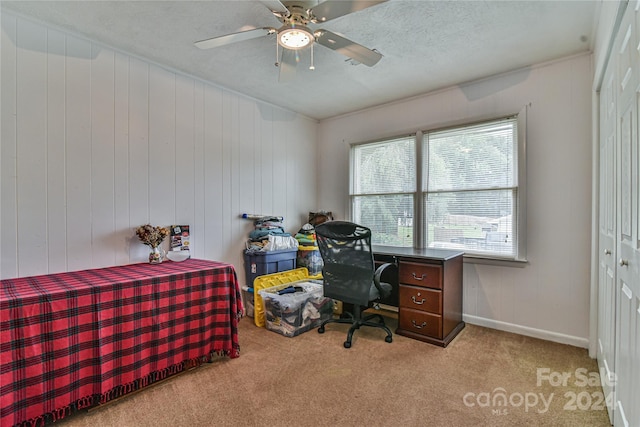 bedroom featuring ceiling fan, light colored carpet, a textured ceiling, and a closet