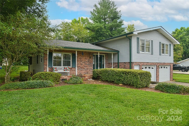 tri-level home featuring a garage, a front lawn, and a porch