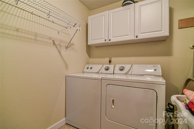 washroom with washing machine and dryer and cabinets