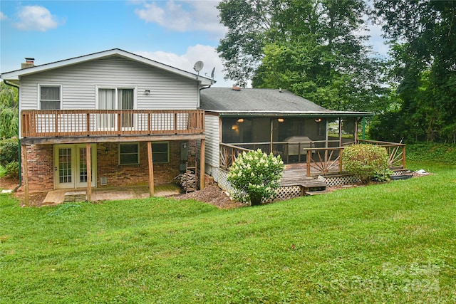 back of property with a lawn, a sunroom, and a deck