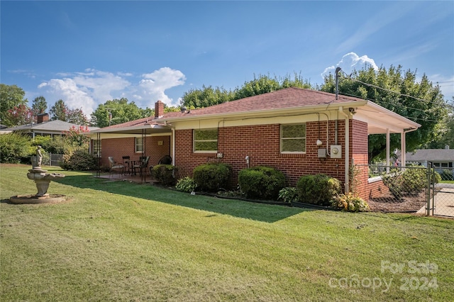 back of property featuring a lawn and a patio