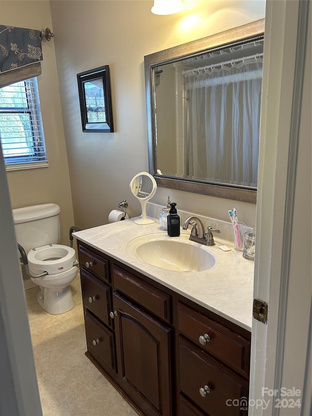 bathroom featuring vanity, curtained shower, and toilet