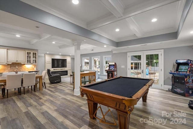 rec room with beam ceiling, light hardwood / wood-style flooring, ornamental molding, french doors, and coffered ceiling