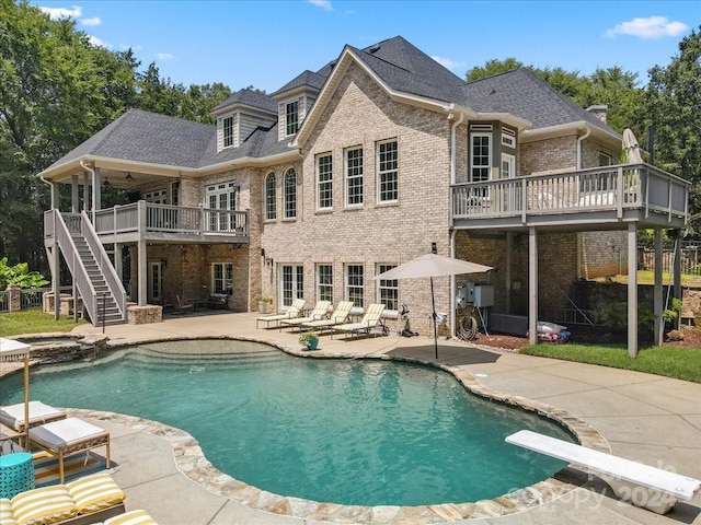 rear view of property with a patio area and a pool with hot tub