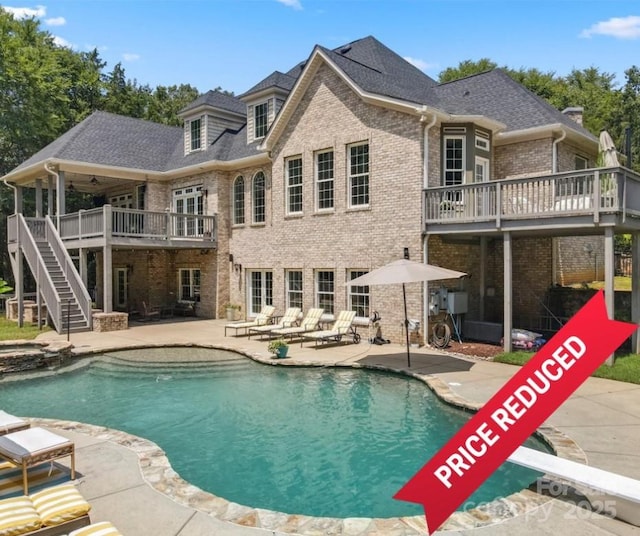 view of swimming pool with a wooden deck, an in ground hot tub, a diving board, and a patio