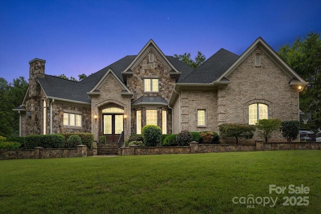 view of front of house featuring a yard and french doors