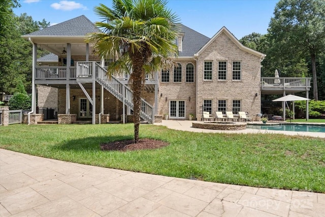 back of property with a yard and a patio