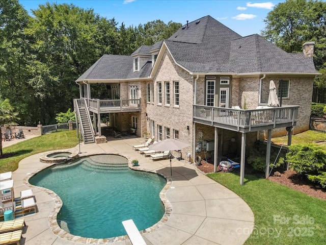 back of property with a pool with hot tub, a patio area, and a lawn